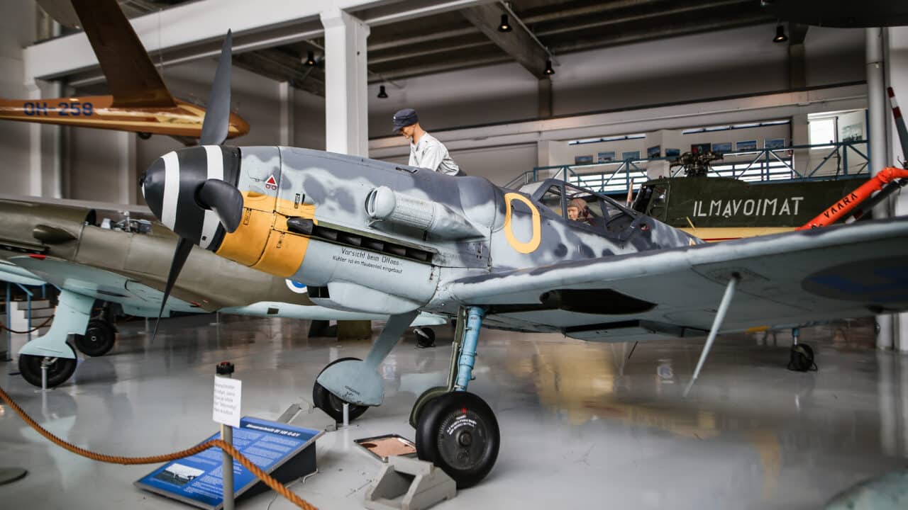 Messerschmitt-hävittäjä näyttelyhallissa. Siiven päällä on mekaanikkoa esittävä nukke, joka käynnistää konetta veivaamalla kammesta.