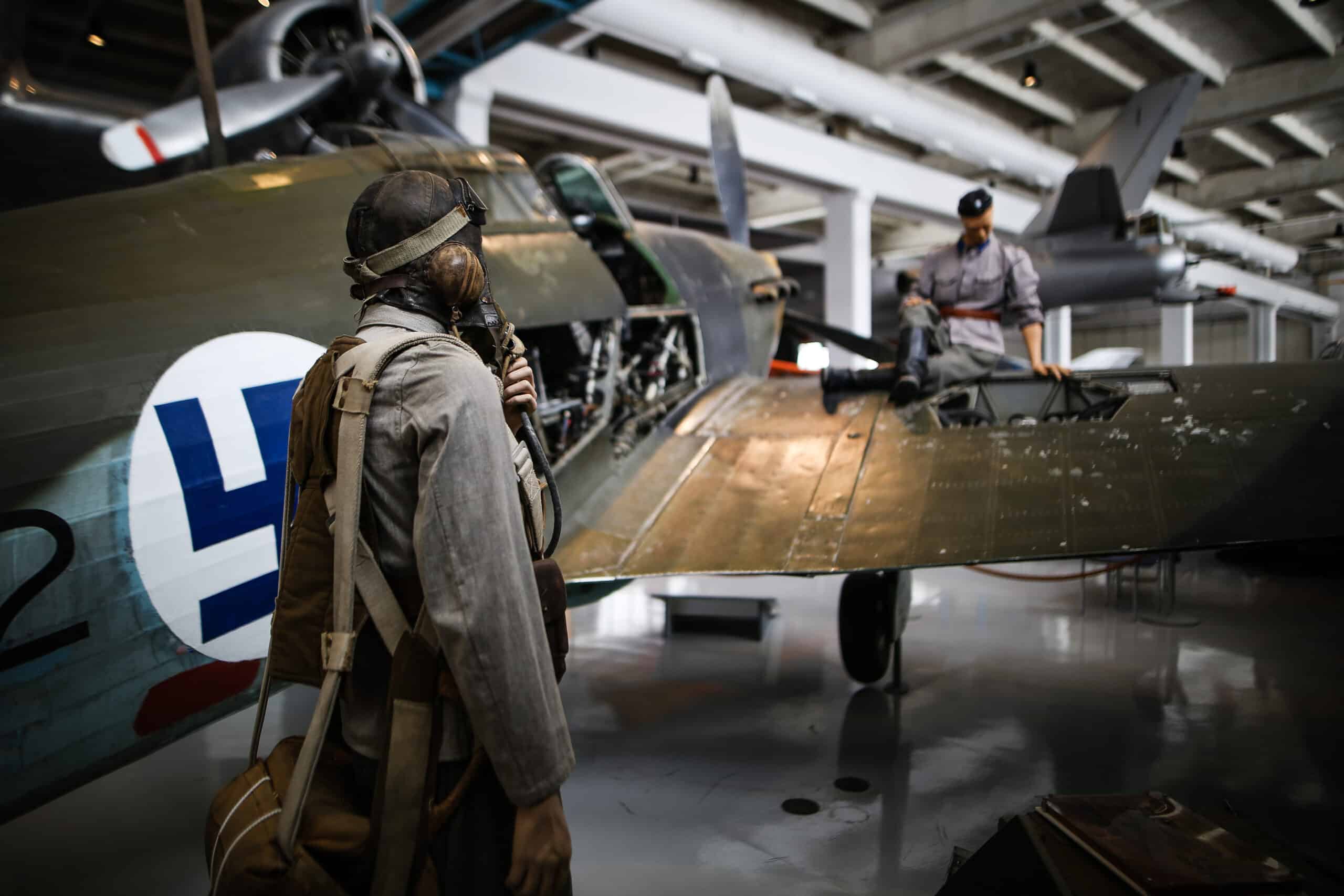 Näyttelyssä olevan Hurrcanen siivellä istuu mekaanikkonukke sota-ajan vaatetuksessa. Lentäjänukke katsoo mekaanikkoa.