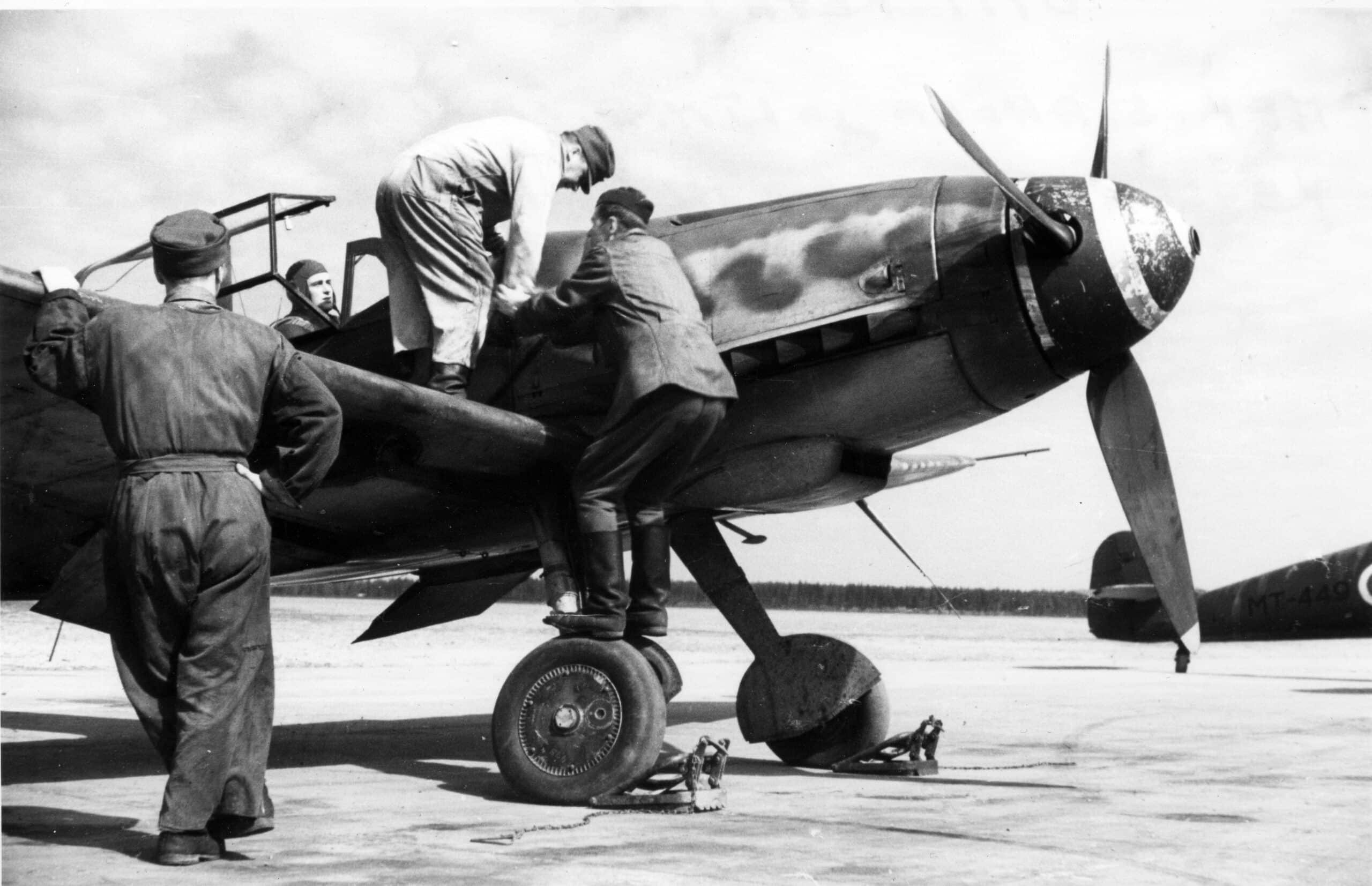 Sota-ajan kuva, jossa kolme mekaanikkoa huoltaa Messerschmitt-konetta.